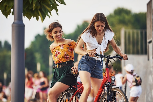 Deux amies à vélo s'amusent dans le parc près de la rampe.