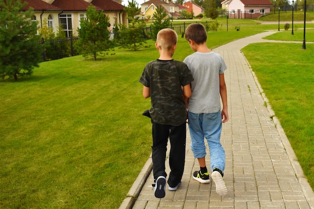 Deux amis amis suivent le chemin en été. Amitié de garçon pour enfants.