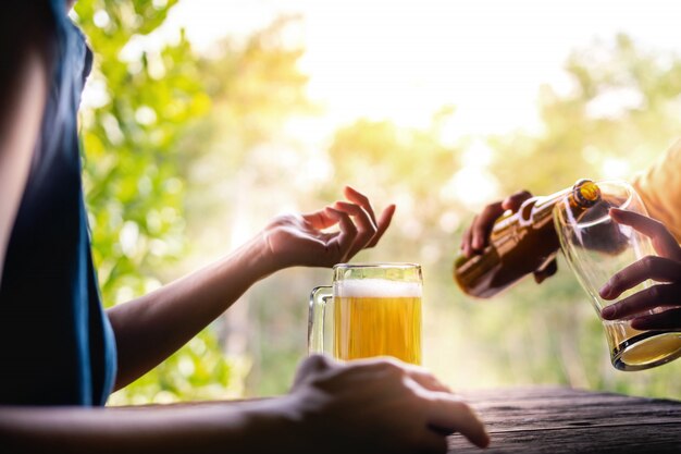 Deux amis buvant de la bière et discutant d&#39;un sujet au balcon en été