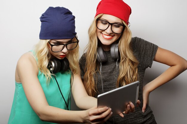 Deux amis filles hipster utilisent une tablette numérique