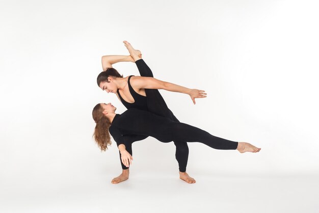 Deux amis de flexibilité dansant, faisant des performances. Prise de vue en studio, isolé sur fond blanc