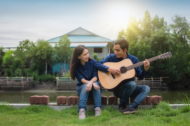 Deux amis jouent de la guitare reste en été heureux en vacances