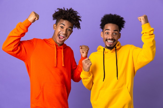 Deux amis masculins joyeux dans des sweats à capuche colorés