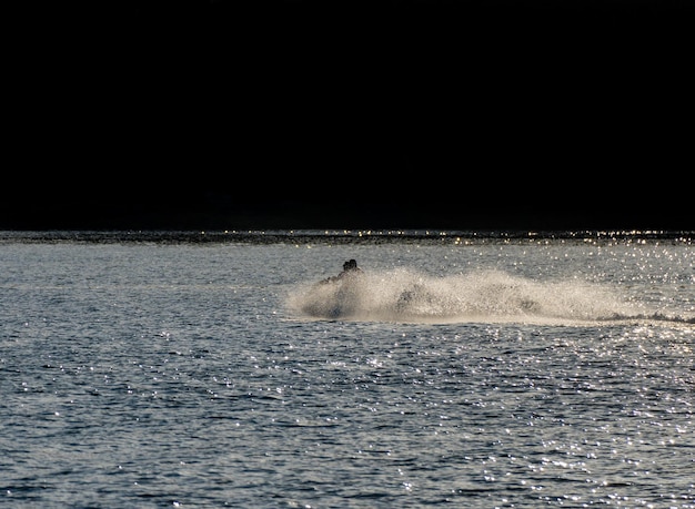 Deux amis profitant du jet ski dérapant à grande vitesse sur la plage de Boiro