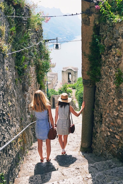 Deux amis regardant la vue sur l'océan. Copines voyageant en Italie en vacances d'été à la plage explorant pour découvrir un style de vie insouciant.