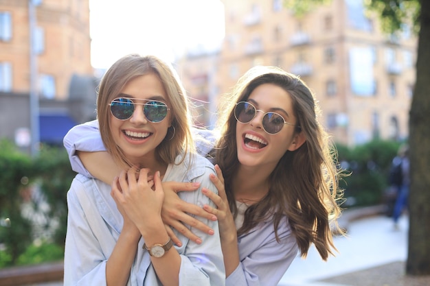 Photo deux amis riants profitant d'un week-end ensemble et faisant du selfie sur fond de ville.