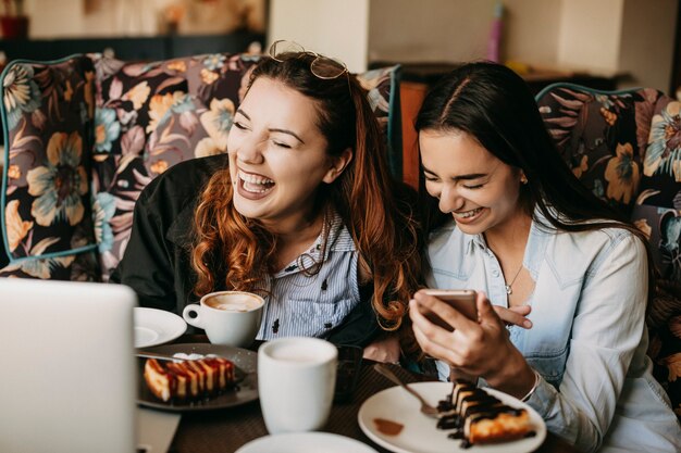 Deux amis s'amusant à rire assis dans un café.