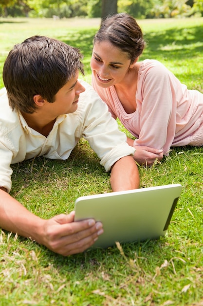 Deux amis se regardent en utilisant une tablette ensemble