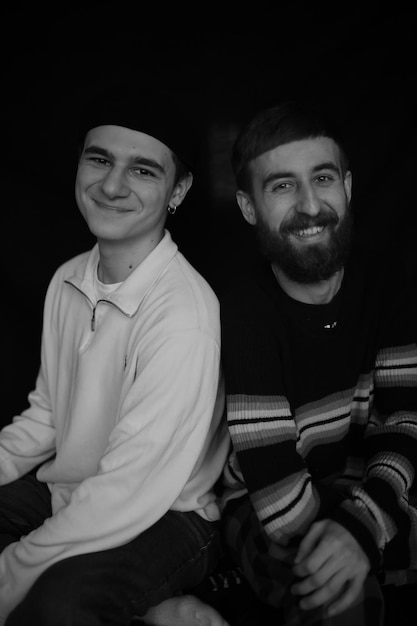 Deux amis souriants posant pour la caméra Amis Deux garçons Les frères sont assis côte à côte