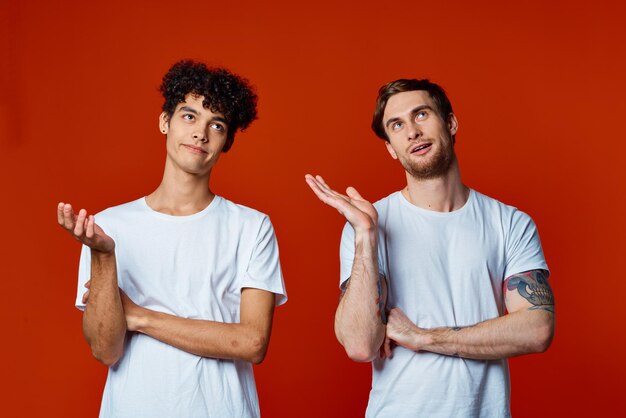 Photo deux amis en t-shirts blancs se tiennent côte à côte isolés communication d'arrière-plan photo de haute qualité