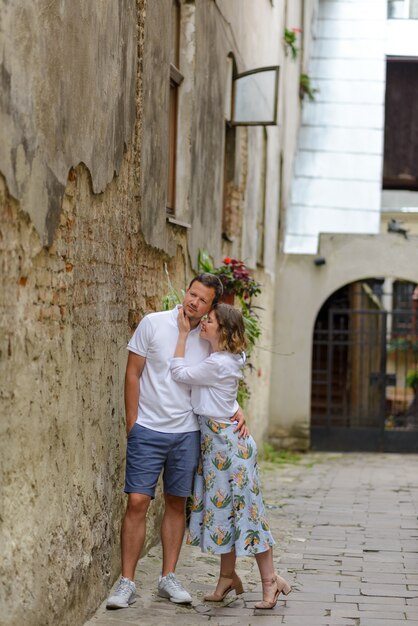 Deux amoureux s'embrassent dans les rues de la vieille ville lors d'un rendez-vous. Un couple se tient près d'un vieux mur de briques.