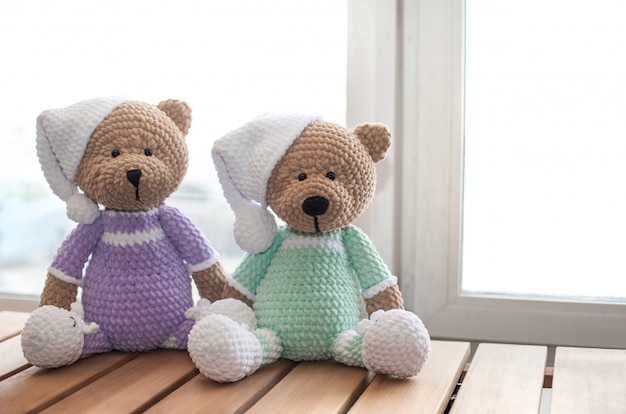 Deux animaux en peluche brun ours en peluche sur table en bois.