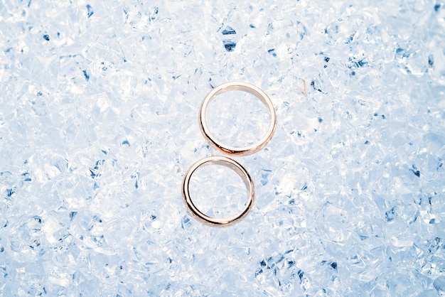 Deux anneaux de mariage en or sur glace.