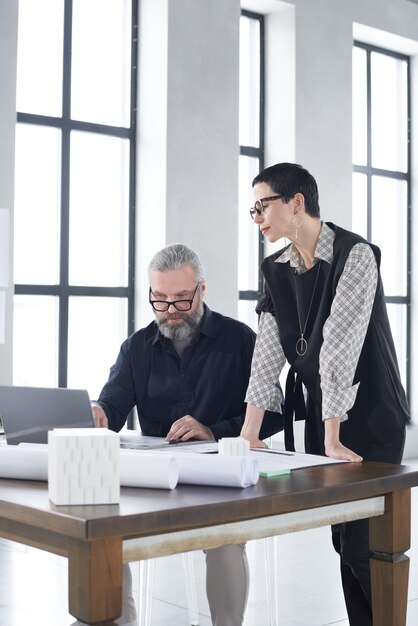 Deux architectes discutant du projet et du plan directeur à la table travaillant en équipe au bureau