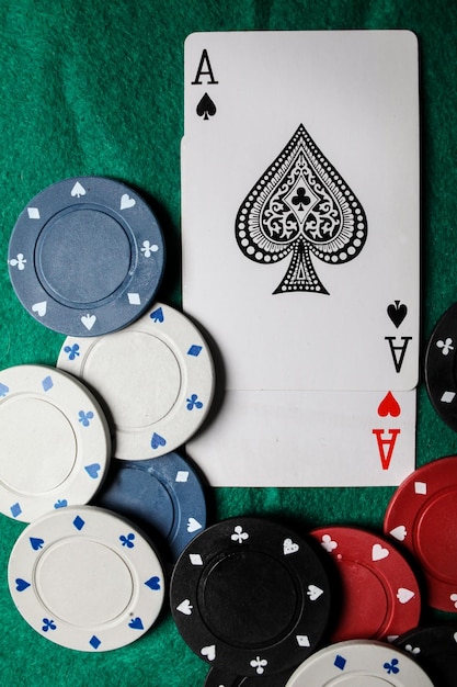 deux as sur la table de jeu verte. deux cartes à jouer et jetons de poker sur une table de casino verte.