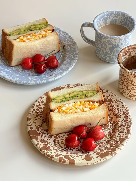 Deux assiettes de sandwichs avec une tasse de café sur le côté.