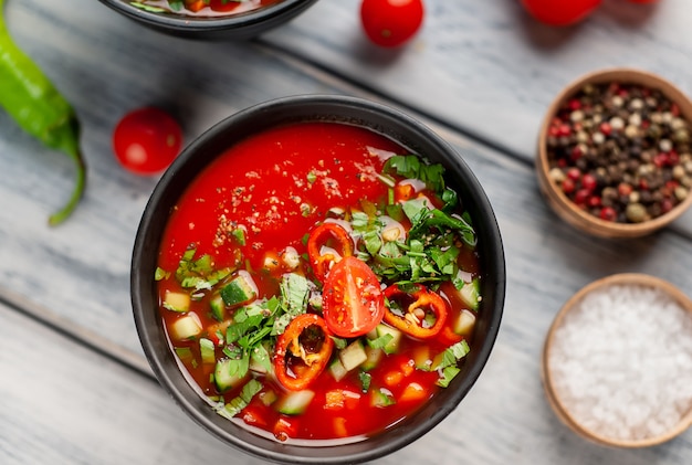 Deux assiettes de soupe de tomate gaspacho froide espagnole traditionnelle sur fond de bois