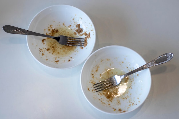 Deux assiettes vides sales avec des fourchettes après la vue de dessus du foie de morue