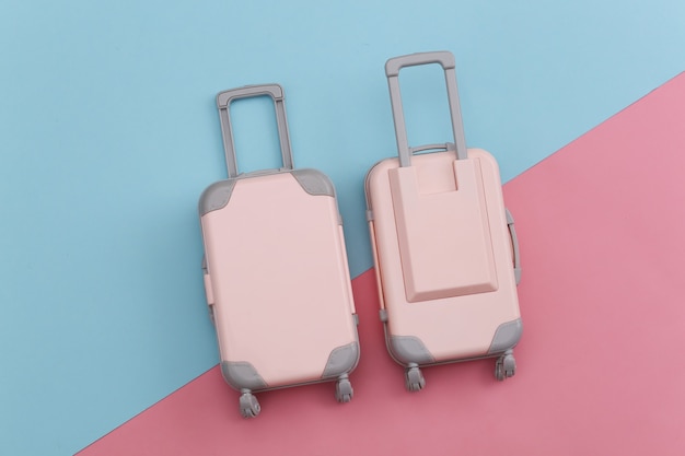 Deux bagages de voyage jouet sur pastel bleu rose. Planification de voyage