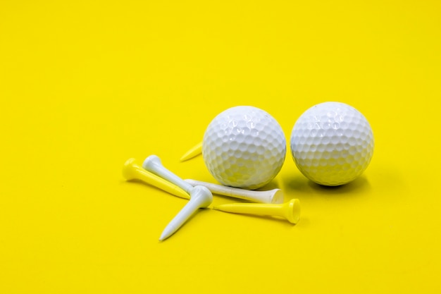 Photo deux balles de golf sont sur fond jaune avec des tees