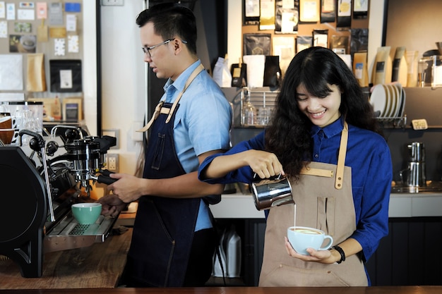 Deux de barista asiatique faisant café latte ou cappuccino dans un café