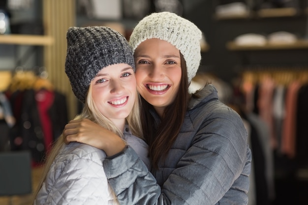 Deux beaux amis avec des vêtements d&#39;hiver, souriant à la caméra