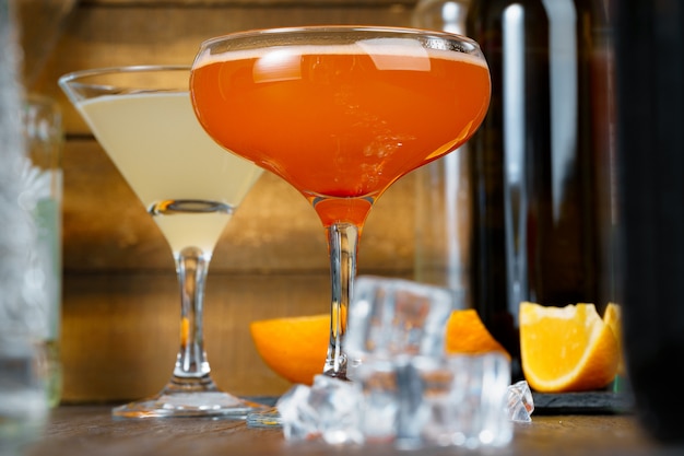 Deux beaux cocktails servis sur un comptoir de bar en bois