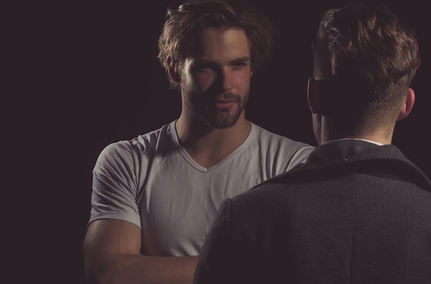 Photo deux beaux hommes debout avec des visages opposés