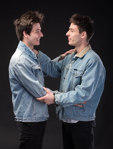 Deux beaux jeunes hommes sur fond noir. Deux frères