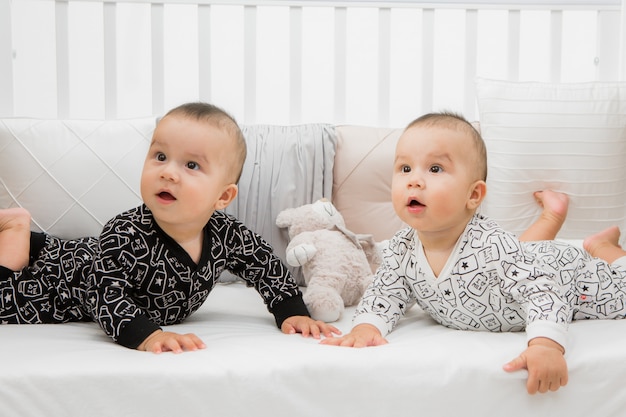 deux bébés au lit gris