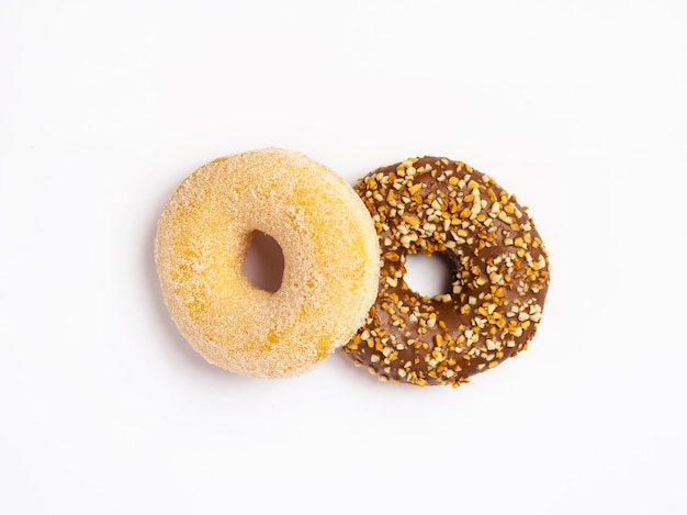 Deux beignets isolés sur une surface blanche, vue du dessus