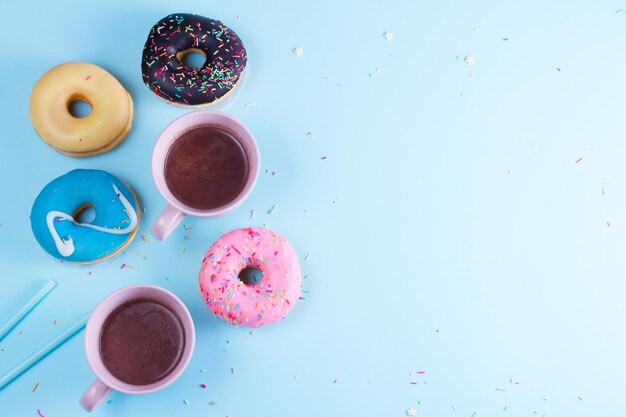 Deux beignets sucrés au cacao sur fond bleu avec espace de copie, scène vue de dessus avec espace de copie