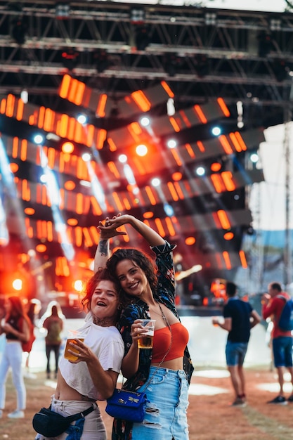 Deux belles amies buvant de la bière et s'amusant lors d'un festival de musique