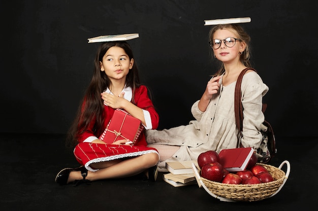 deux belles copines écolières ont un plaisir assis avec des livres