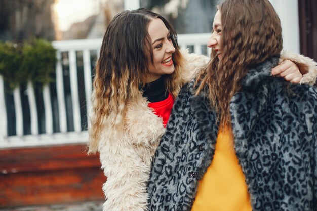 deux belles et élégantes filles en vêtements de mode se promènent dans la ville de printemps