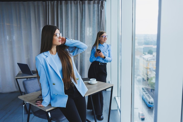 Deux belles femmes d'affaires au bureau et faire des affaires Femme d'affaires au bureau avec des lunettes et un téléphone