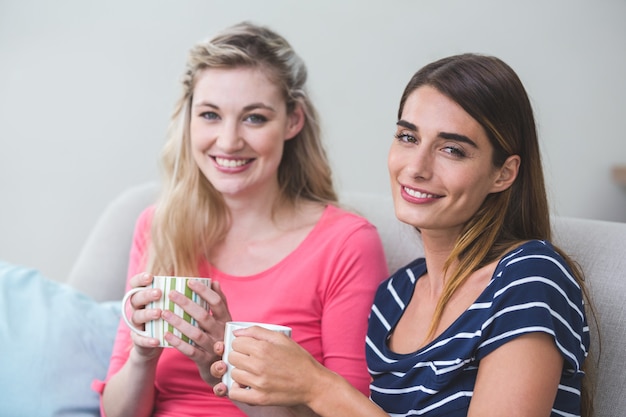 Deux belles femmes assises côte à côte avec une tasse de café