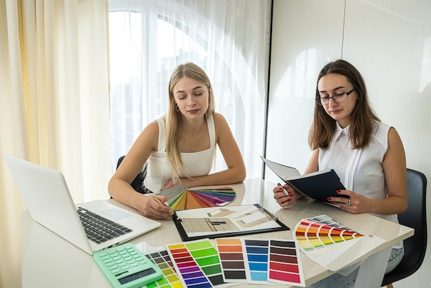 Deux belles femmes designers travaillant sur de nouveaux designs de nouvelles chambres à la table Concept de design