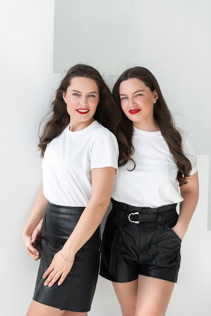 Deux belles femmes soeurs jumelles posant fond blanc