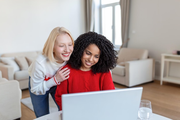 Deux belles femmes utilisant un ordinateur portable pour un appel vidéo en ligne et un toast en ligne avec leurs amis Fête en ligne pour amis