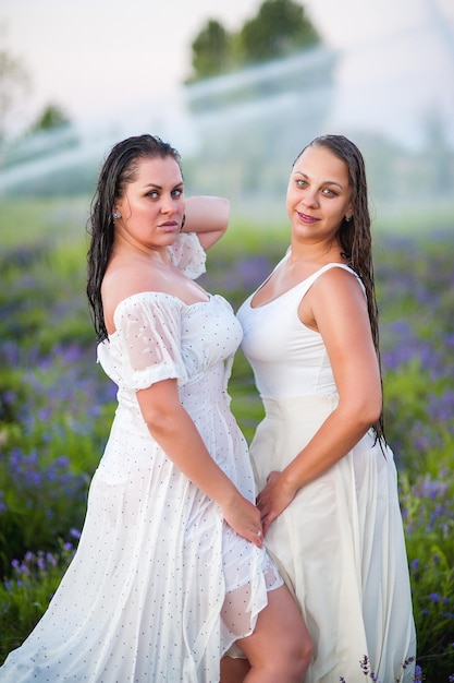 Photo deux belles filles mouillées en lavande sous un fantan