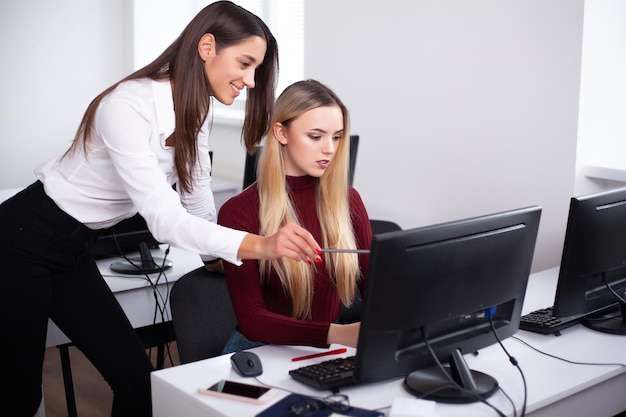 Deux belles filles travaillent dans le bureau d'une société de conseil