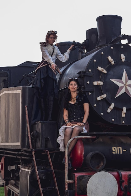 Deux belles filles en vêtements steampunk sur le fond du train