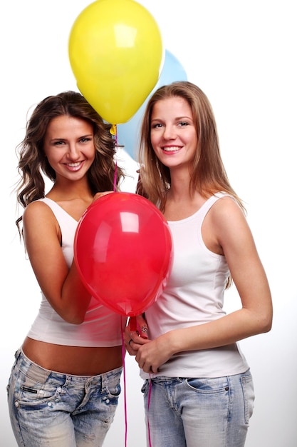 Deux belles jeunes copines avec des ballons de couleur