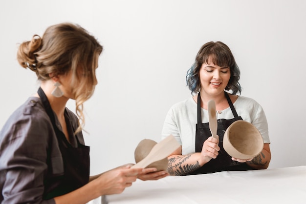 Deux belles jeunes femmes potier créant des plats