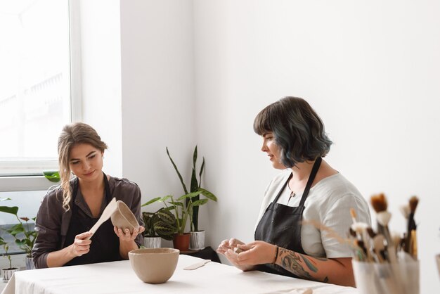 Deux belles jeunes femmes potier créant des plats