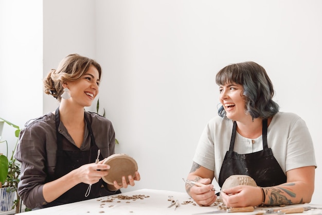 Deux belles jeunes femmes potier créant des plats