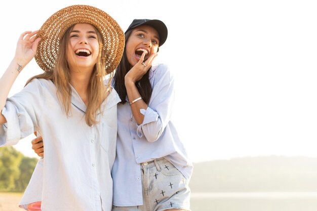 Deux belles jeunes femmes se promenant sur une plage. Amies marchant sur la plage et riant un jour d'été.