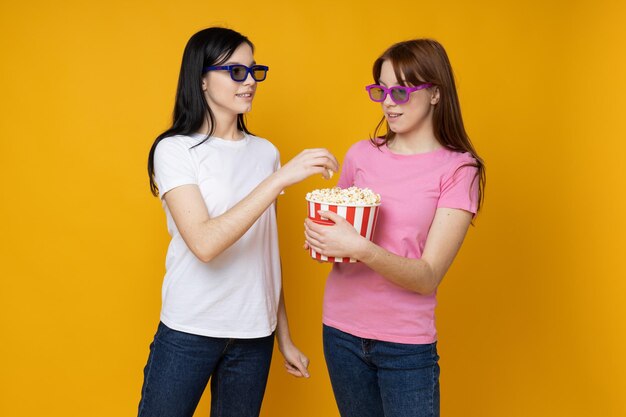 Deux belles jeunes femmes sœurs jumelles sur fond jaune