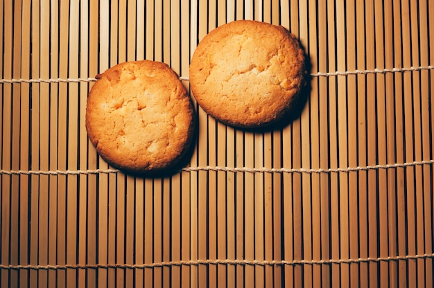 Deux biscuits croustillants ronds, sur du bambou texturé, design simple